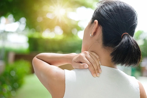 A woman touching her neck.