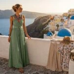 Γυναίκα με πράσινο maxi φόρεμα σε βεράντα στη Σαντορίνη, ιδέα για το τι να φορέσω στο νησί