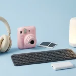 Gadgets για φοιτητές σε γαλάζιο φόντο: ακουστικά, instant κάμερα, πληκτρολόγιο και φορητό φωτιστικό