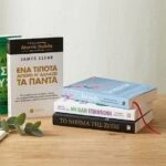 Στοίβα με βιβλία αυτοβελτίωσης του 2026 πάνω σε ξύλινο τραπέζι με καφέ και σημειωματάριο