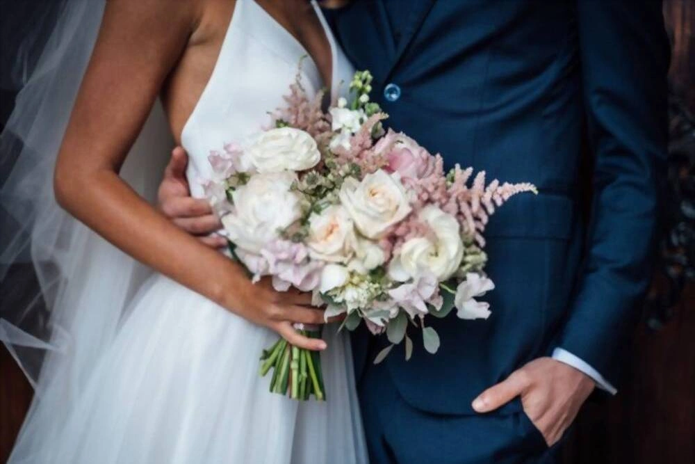 Γαμήλια ανθοδέσμη από λευκά και ροζ τριαντάφυλλα και με νιόπαντρο ζευγάρι