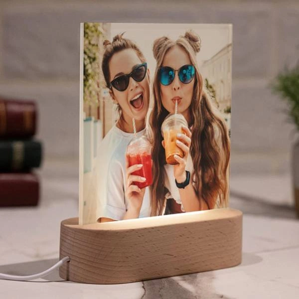 Φωτιζόμενο plexiglass κάδρο με ξύλινη βάση LED που προβάλλει φωτογραφία δύο φίλων με ροφήματα σε εσωτερικό χώρο.
        loading=