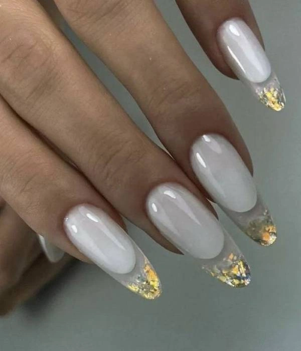Νύχια για νύφη με λευκή βάση και χρυσό και ασημί foil στις άκρες, σε σχήμα αμυγδάλου.