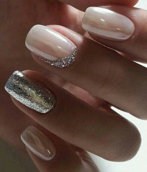 Νυφικά νύχια με γκλίτερ και στρας, σε οβάλ σχήμα, με συνδυασμό nude και ασημί χρώματος.
