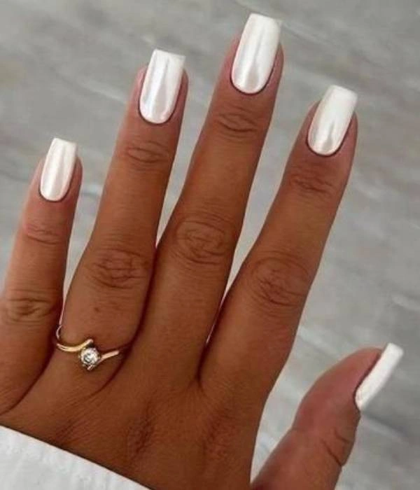 Λευκά νυφικά νύχια με περλέ φινίρισμα, σε τετράγωνο σχήμα, με ένα χρυσό δαχτυλίδι με διαμάντι.