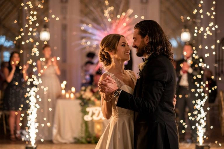 Νύφη και γαμπρός χορεύουν τον πρώτο τους χορό σε μια γαμήλια δεξίωση με πυροτεχνήματα