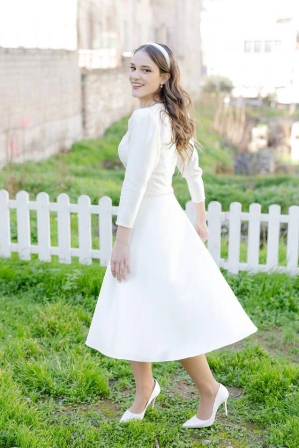 Κομψό λευκό νυφικό φόρεμα σε μήκος midi, ιδανικό για πολιτικό γάμο.