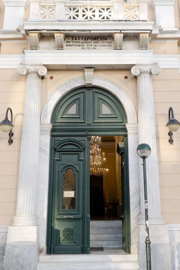 Είσοδος του ιστορικού Ταχυδρομείου με πράσινη πόρτα και μαρμάρινες κολώνες.