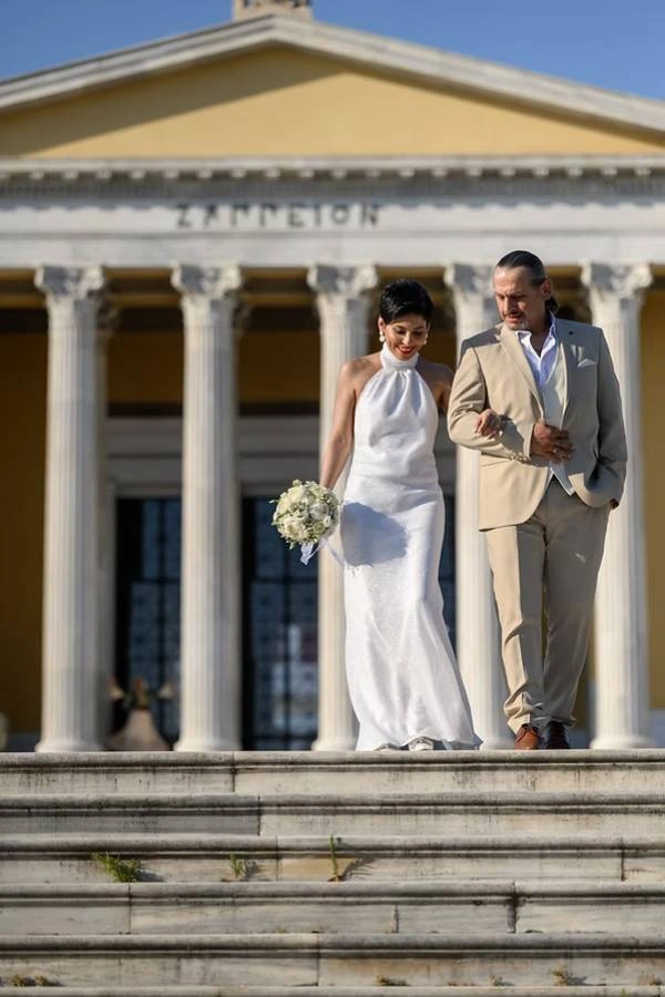 Νεόνυμφο ζευγάρι κατεβαίνει τα σκαλιά του Ζαππείου Μεγάρου στην Αθήνα.