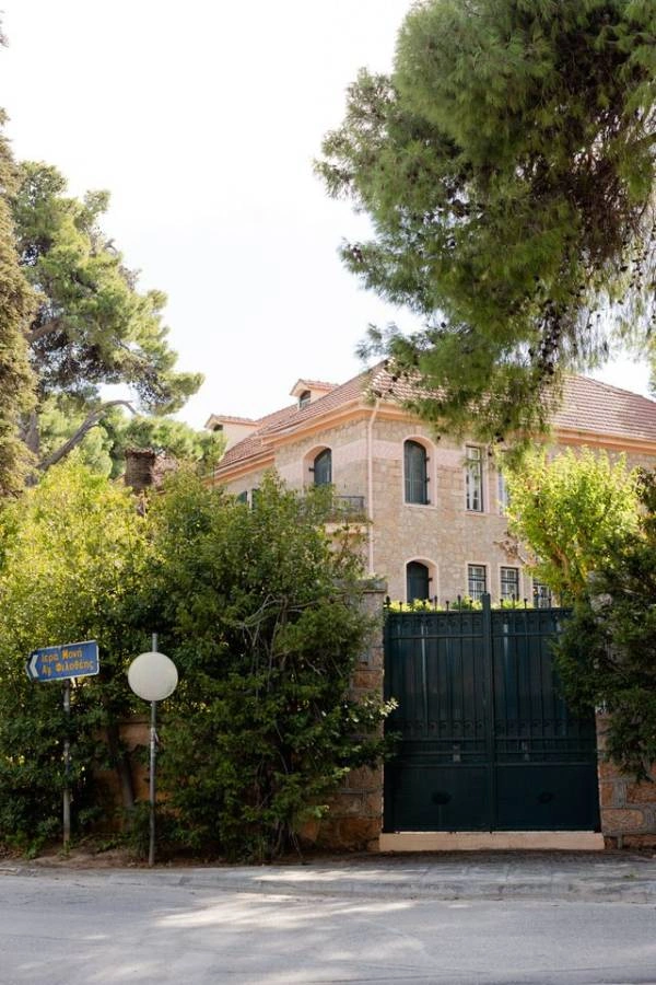 Φωτογραφία της εισόδου ενός δημαρχείου με πράσινη πύλη και πινακίδα οδού