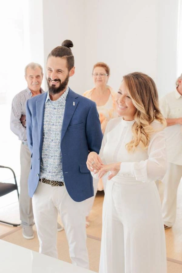 Φωτογραφία από τελετή πολιτικού γάμου, δείχνοντας το ζευγάρι ευτυχισμένο.