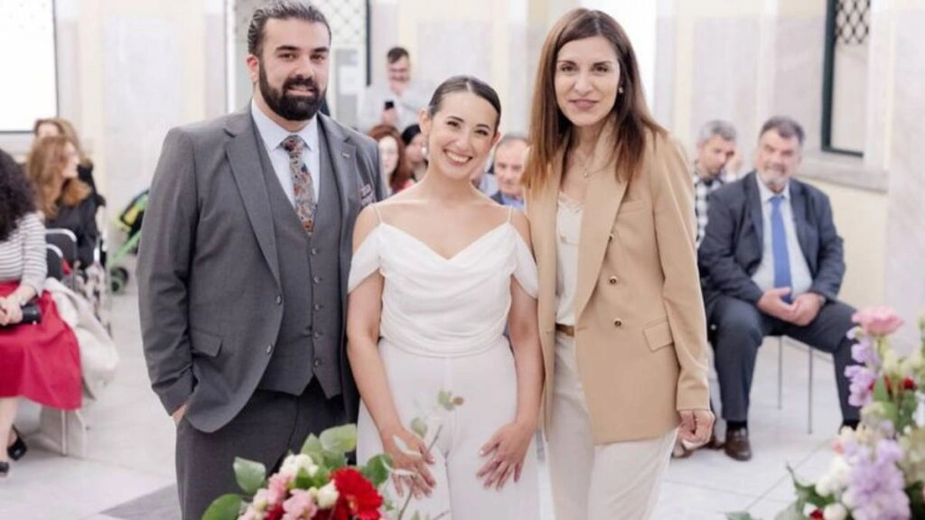Πολιτικός γάμος. Το ζευγάρι ποζάρει χαμογελαστά με τη Δήμαρχο ή τον αρμόδιο Ληξίαρχο κατά την τέλεση του πολιτικού τους γάμου.