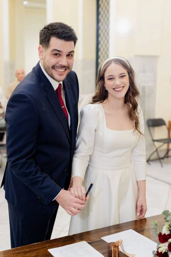 Φωτογραφία νύφης και γαμπρού κατά την τελετή του πολιτικού τους γάμου, ετοιμάζονται να υπογράψουν.