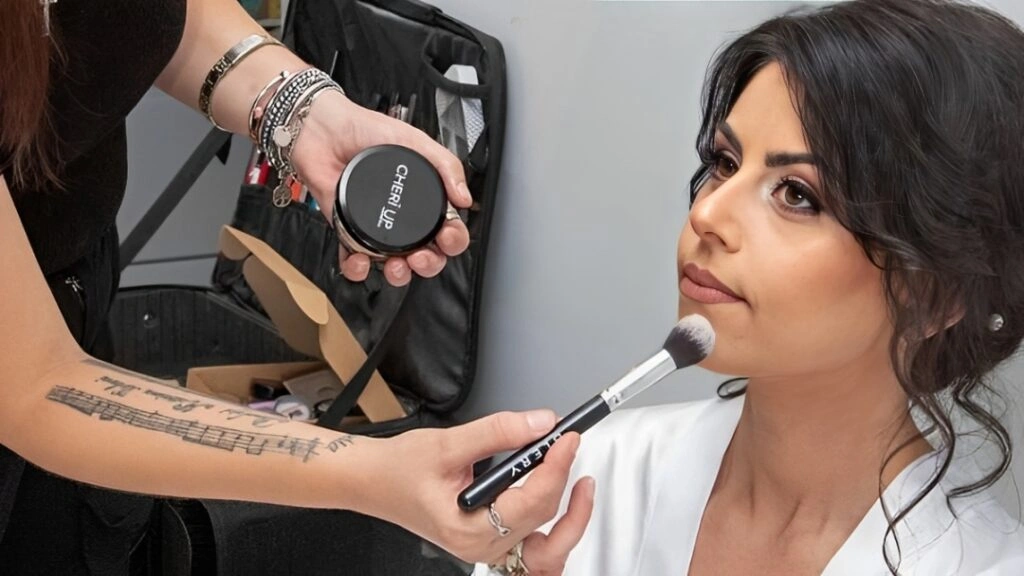 Η makeup artist Christina Matosi εφαρμόζει πούδρα σε νύφη πριν τον γάμο της, με ήρεμη και συγκεντρωμένη έκφραση