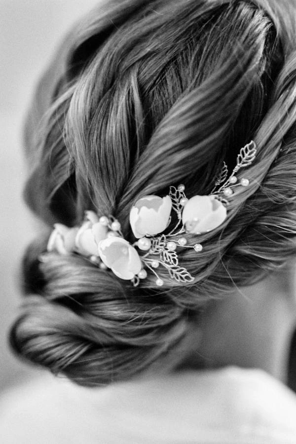 Πλεγμένο χαμηλό updos με λουλούδια πορσελάνης και φύλλα