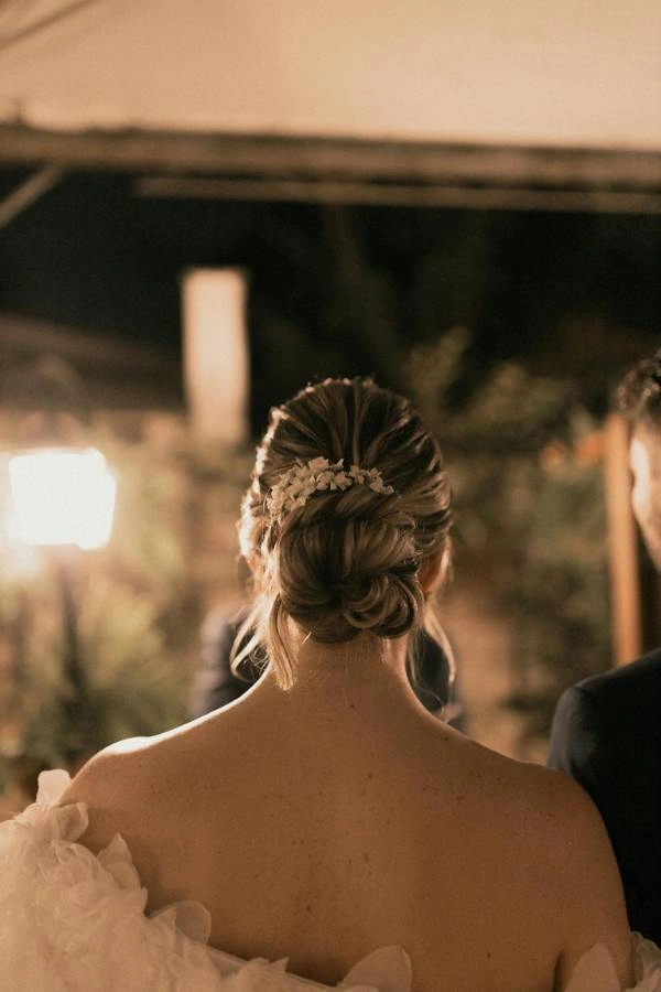 Ρομαντικός κότσος με φυσικά λουλούδια σε βραδινό φωτισμό