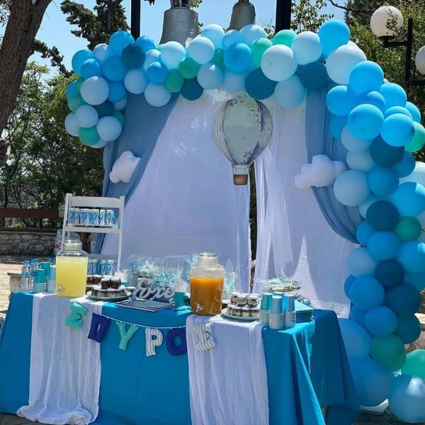 Candy bar βάπτισης με θέμα το αερόστατο και γιρλάντα με γαλάζια μπαλόνια.