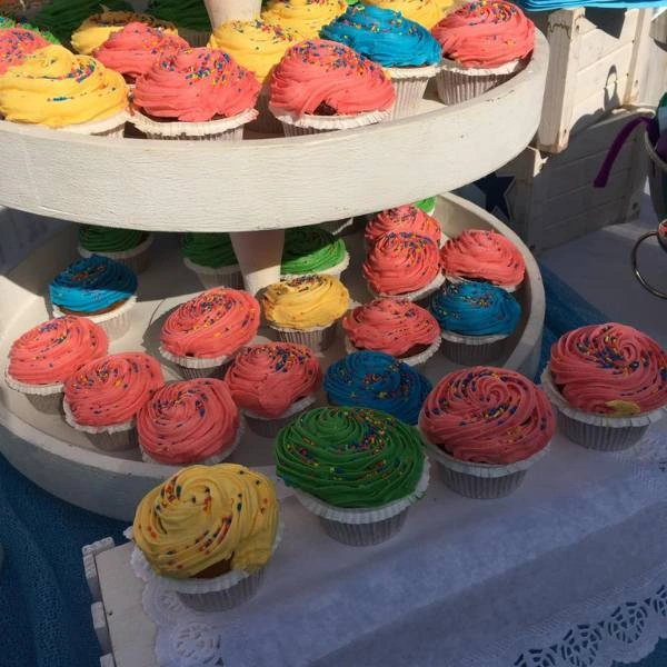 Cupcakes σε πολύχρωμα χρώματα για βάπτιση με θέμα ζαχαροπλάστης
