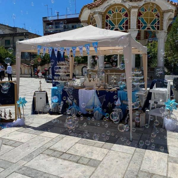 Γενική άποψη από την καλοκαιρινή βάπτιση με φόντο εκκλησάκι και φυσαλίδες