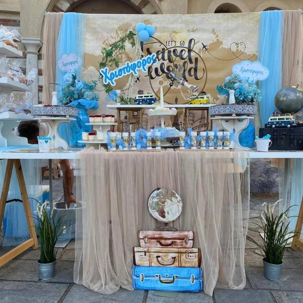 Κεντρική σύνθεση με βαλίτσες και γήινα χρώματα σε στολισμό βάπτισης ταξίδι.