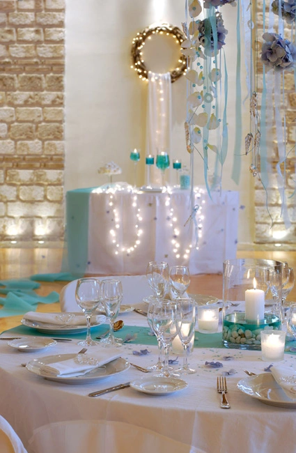 Ρομαντικός στολισμός γάμου σε αποχρώσεις Tiffany blue με κεριά, λευκά τραπέζια, φωτιστικά και γιρλάντες από τη Vassiliki Creations