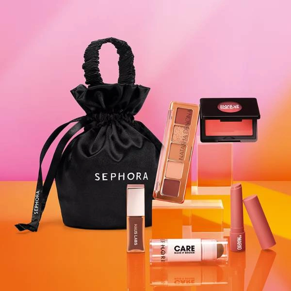 Σετ Sephora Favorites Golden Glow με γκλος χειλιών, bronzer σε στικ, ρουζ κοραλί και μίνι παλέτα σκιών δίπλα σε μαύρο πουγκί Sephora σε ροζ πορτοκαλί φόντο.
        loading=