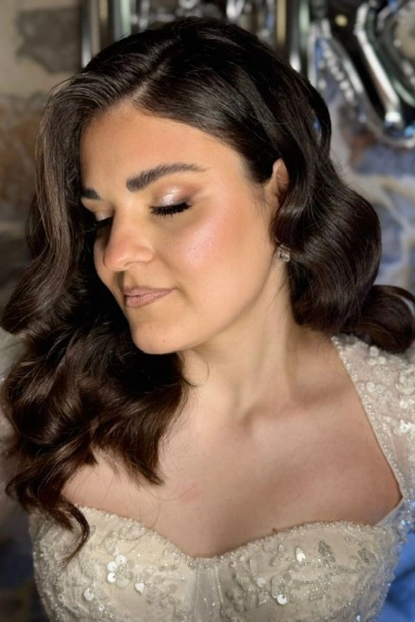 Νυφικό χτένισμα με εντυπωσιακές Hollywood waves και φυσικό, λαμπερό bridal μακιγιάζ με γήινες αποχρώσεις και απαλή λάμψη.