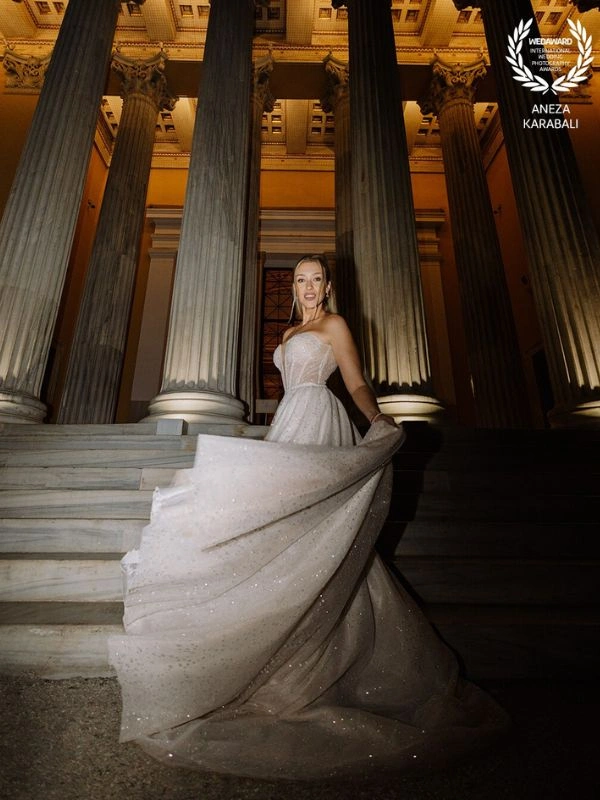 Πορτρέτο νύφης σε σκαλιά νεοκλασικού κτιρίου με εντυπωσιακό νυφικό