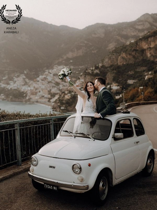Ζευγάρι νεόνυμφων σε λευκό αυτοκίνητο σε φωτογράφιση γάμου σε προορισμό