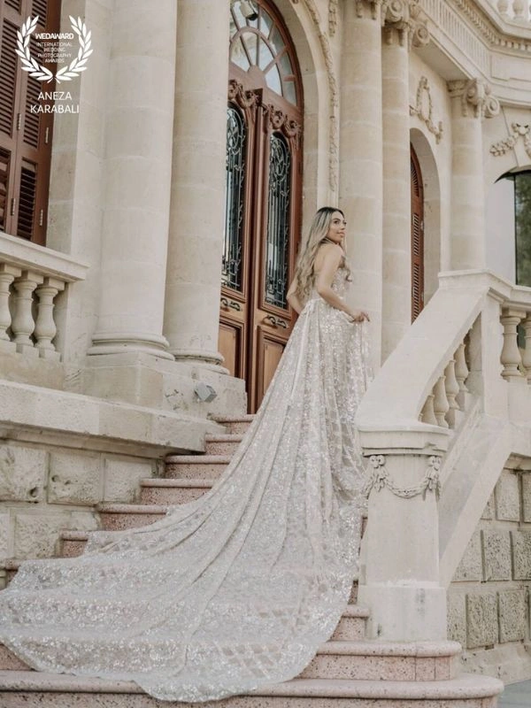 Νύφη σε σκάλα αρχοντικού με μακρύ κομψό νυφικό