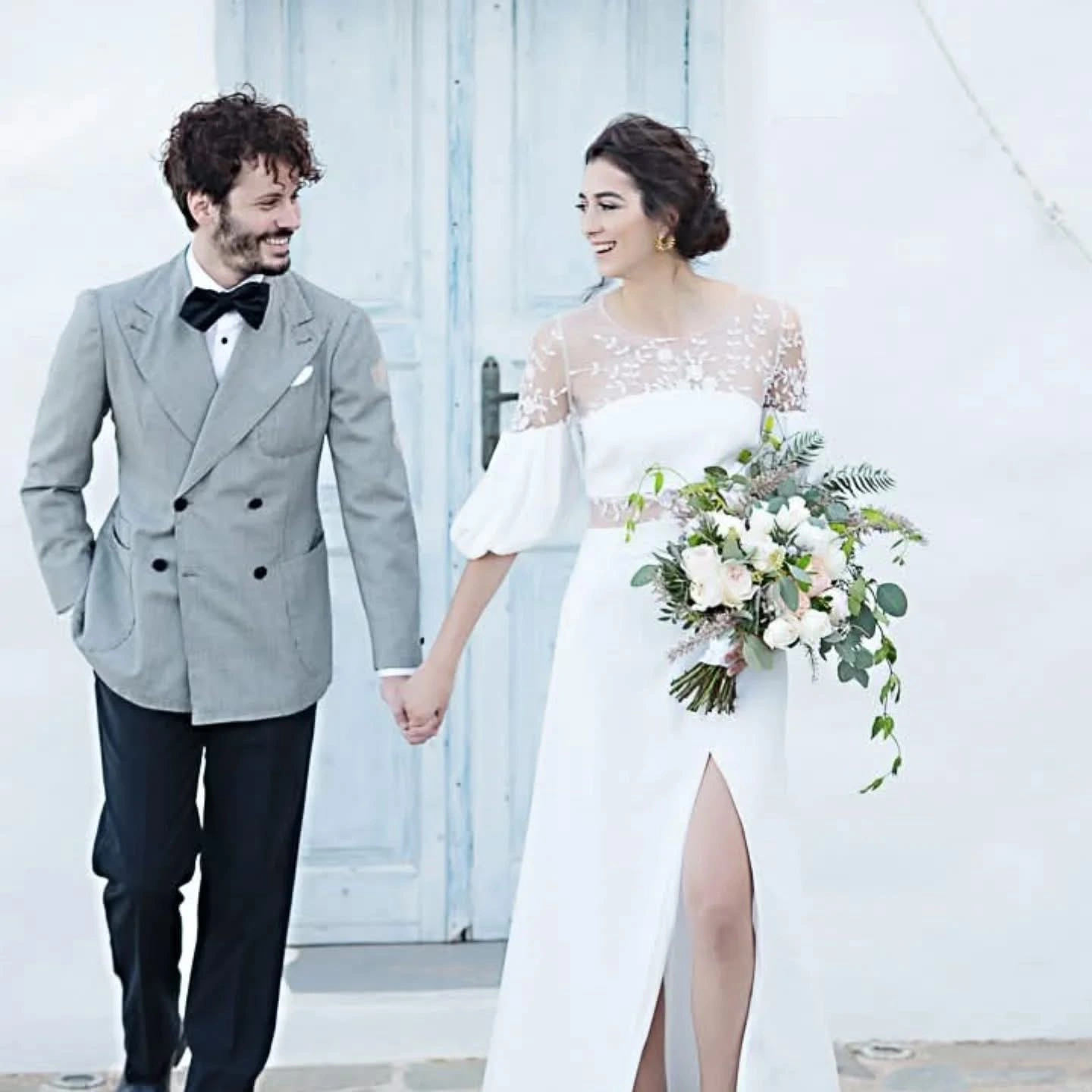 Ζευγάρι σε minimal αισθητική με λευκό φόντο και νυφική ανθοδέσμη από την Wedding Stars