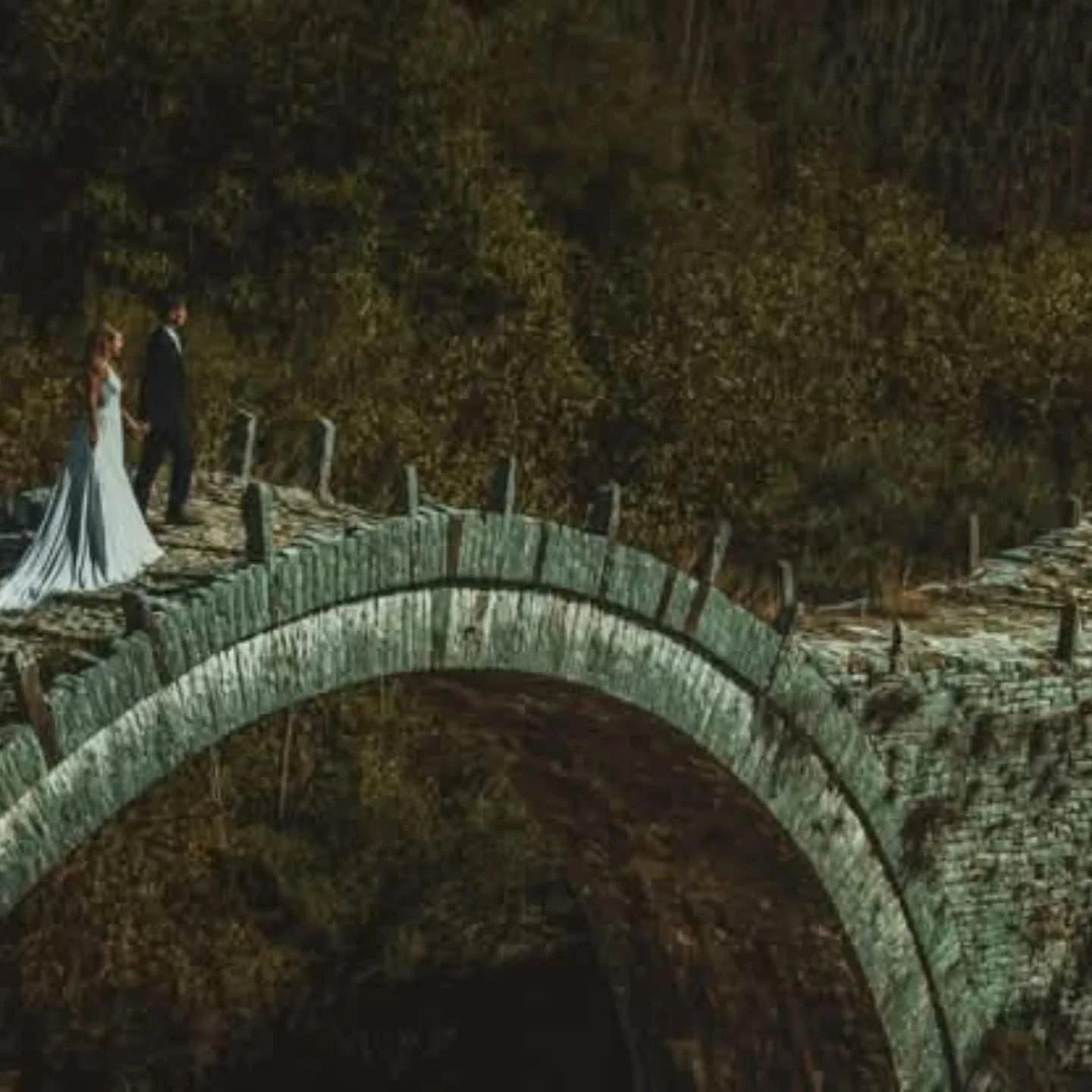 Ζευγάρι σε ρομαντική pre wedding φωτογράφιση πάνω σε πέτρινο γεφύρι από την Wedding Stars